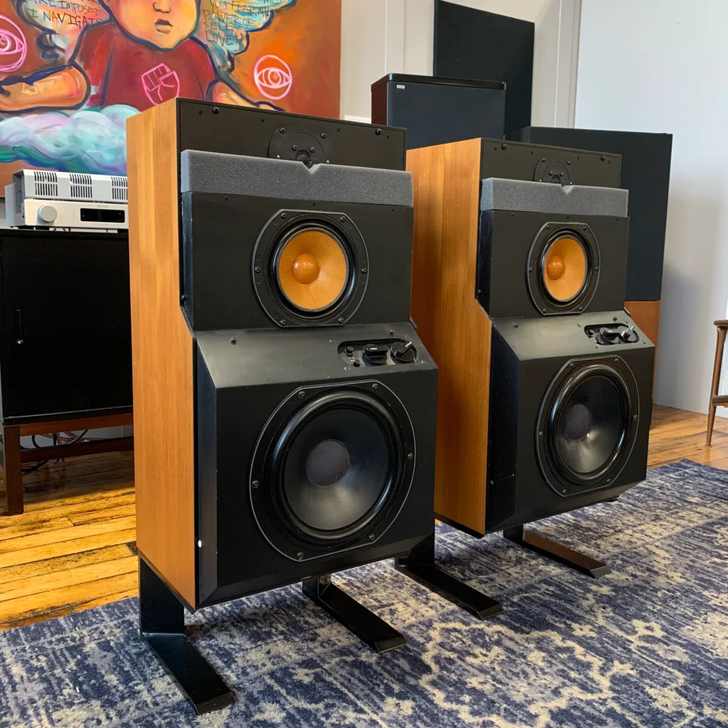 The same pair of DM6 speakers with the grilles removed, showing the Kevlar midrange driver and the "stepped" baffle intended to improve phase linearity