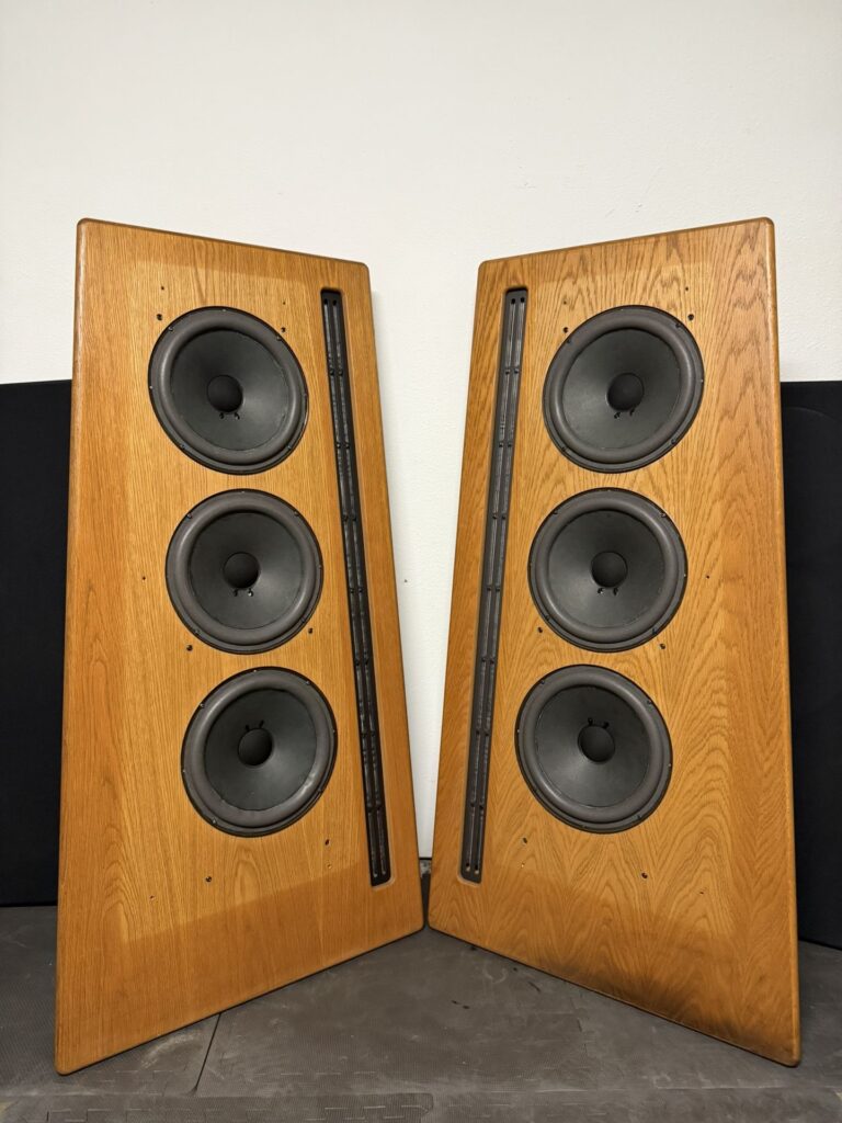 A pair of Carver Amazing Silver loudspeakers, each equipped with a long ribbon driver for the upper frequencies and three woofers for the lower frequencies